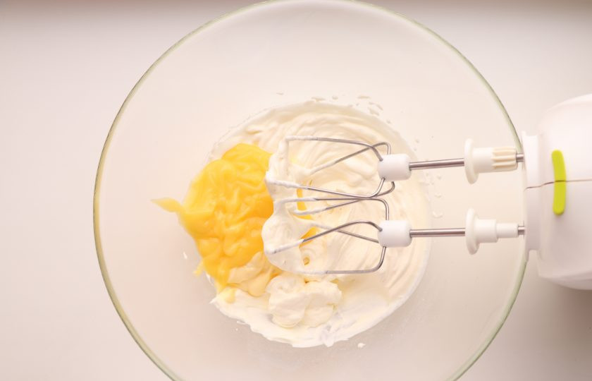 1. Этап. Лимонный тирамису: К взбитым сливкам добавьте 100 г охлажденного лимонного курда, перемешайте.