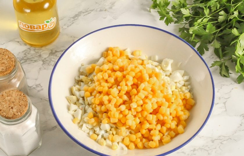 1. Этап. Салат с тунцом и кукурузой в тарталетках: Отожмите консервированную кукурузу от маринада и высыпьте в емкость к яичной нарезке.