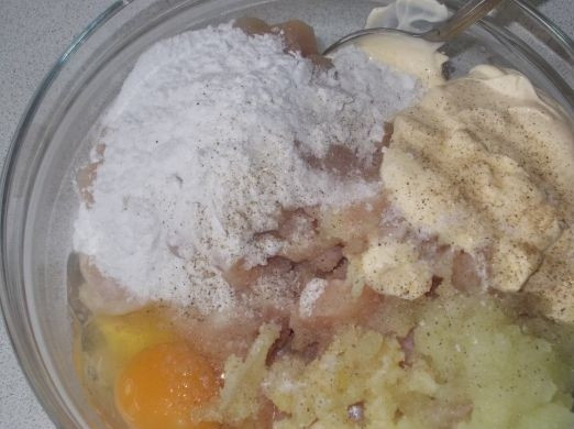 1. Этап. Курица по-албански: Нарезанное филе выкладываем в миску, добавляем лук, чеснок, крахмал, майонез и одно яйцо, солим и перчим.