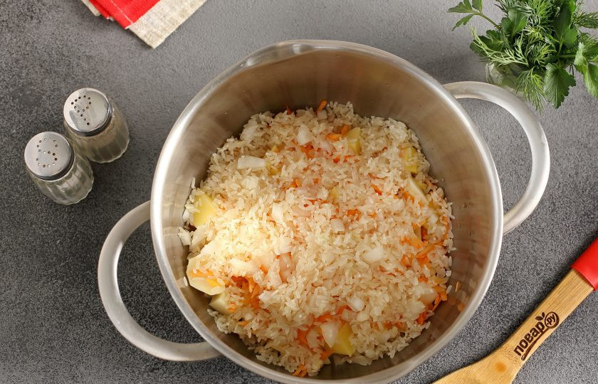 1. Этап. Рисовый диетический суп: Добавьте тертую морковь, нарезанный мелкими кубиками лук и промытый рис.