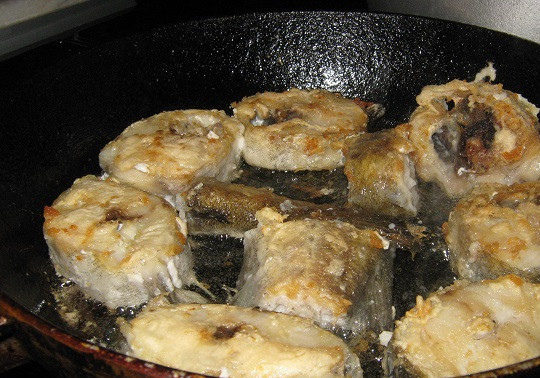 1. Этап. Минтай жареный с луком: 2. В подготовленной мисочке с мукой обвалять каждый кусочек рыбы. На сковороду налить растительное масло и хорошо его разогреть. Отправить туда рыбу и обжарить до золотистой корочки с двух сторон.