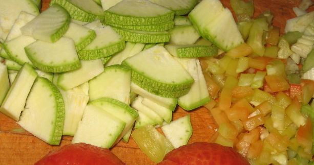 1. Этап. Ризотто с сыром Пармезан: Маленькими кубиками нарезаем перец и сельдерей. Кабачок режем средними ломтиками. Помидоры опускаем в кипяток, затем охлаждаем и снимаем с них кожицу, режем кубиками.