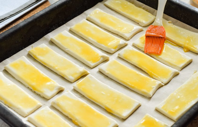 1. Этап. Слойки с медом: Смажьте тесто куриным желтком. Выпекайте в духовке при температуре 180 градусов в течение 30 минут.