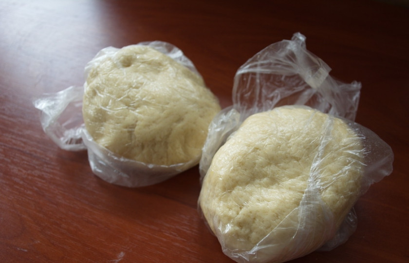 1. Этап. Печенье на кефире с вареньем: Соберите тесто в шар. Разделите тесто на 2 части. Каждую поместите в пакет и отправьте в морозилку на 1 час.