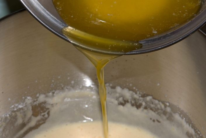 1. Этап. Мадлен: 5. В качественно перемешанное тесто тонкой стрункой влейте охлажденное до комнатной температуры растопленное сливочное масло. Перемешайте.