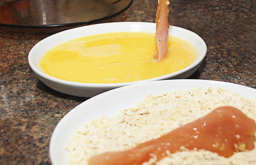 1. Этап. Хрустящие куриные палочки: Куриное филе порежьте на тонкие длинные полоски. Обмакивайте кусочки курицы сначала в яйца, затем изваляйте в панировочных сухарях.