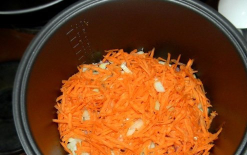 1. Этап. Говядина, тушеная в мультиварке Поларис: К мясу в мультиварку выкладываем натертую на крупной терке морковку и мелко нарезанный лук.
