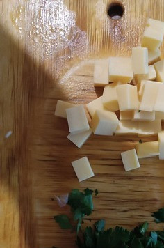 1. Этап. Салат с помидорами и огурцами Мяучка: Сыр нарезаем небольшими кубиками. Петрушку рубим.