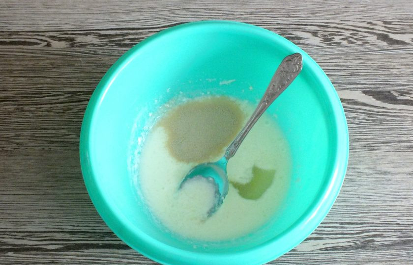 1. Этап. Дучмак с творогом: В чаше соедините теплое кислое молоко, сахар, растительное масло и дрожжи. Хорошо размешайте. Оставьте на 10 минут при комнатной температуре.