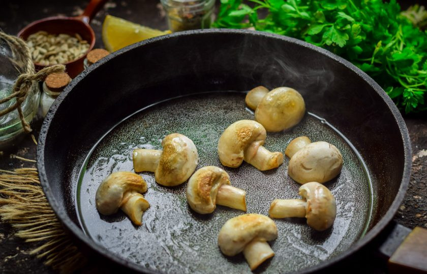 1. Этап. Зеленый салат с грибами: Прогрейте сковороду, слегка смажьте маслом и выложите грибы. Жарьте шампиньоны с обеих сторон по 2-3 минуты.
