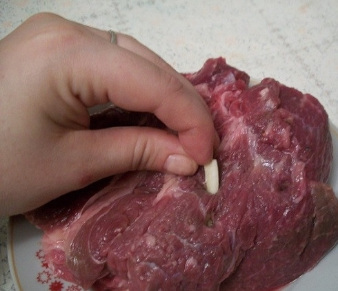 1. Этап. Телятина в духовке: 1. Мясо тщательно зачищаем от пленки и жил, моем хорошенько и вытираем бумажным полотенцем. Делаем глубокие надрезы, чистим чеснок и зубчики запихиваем внутрь надрезов.