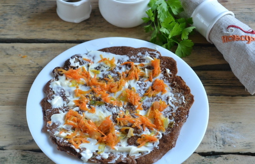 1. Этап. Печеночный торт: 8. На плоскую тарелку положите первый блин, смажьте его майонезом или сметаной, выложите немного обжаренных лука и моркови, накройте вторым блином и повторите процедуру.