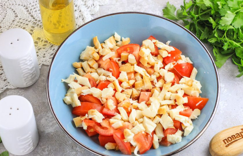 1. Этап. Салат с копченым сыром и помидорами: Нарежьте копченый сыр кубиками: мелкими или средними. Добавьте в емкость.