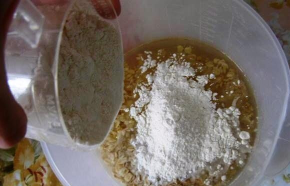 1. Этап. Постное печенье из овсяных хлопьев: Чтобы приготовить вкусное постное печенье из овсяных хлопьев, первым делом слейте рассол из банки консервированных огурцов или помидоров. Налейте его в чашу для блендера, туда же добавьте овсянку, подсолнечное масло, сахар и просеянную муку.