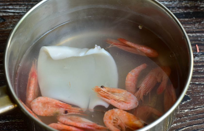 1. Этап. Салат с кальмарами, креветками и ананасами: Отварите креветки в течение минуты, а тушку кальмара в течение двух минут.