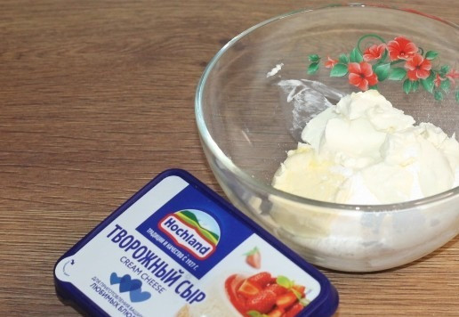 1. Этап. Кекс с кремом из творожного сыра: 15. Пока остывают кексы, приготовим крем. Масло достаем из холодильника и натираем на крупной терке. Добавляем сахарную пудру и творожный сыр Hochland, перемешиваем ложкой.