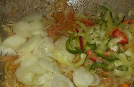 1. Этап. Салат из патиссонов: 3. Вымойте и очистите перец от семян, затем разрежьте каждую перчинку пополам и нарежьте полукольцами. Очистите лук и нарежьте его тонкими полукольцами, выложите овощи в казанок.