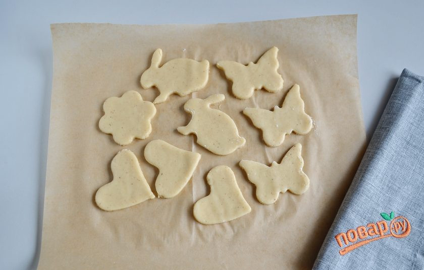 1. Этап. Печенье Елочные игрушки: Уберите лишнее тесто с пергамента. Прогрейте духовку до 200 градусов, поставьте печенье выпекаться на 5-7 минут.