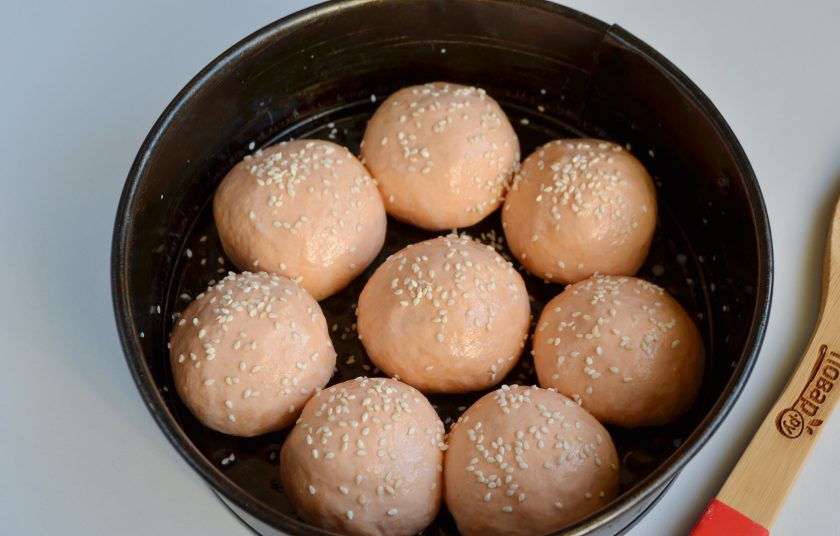 1. Этап. Томатные булочки: 8. Смажьте форму маслом растительным. Положите булочки, смажьте их молоком и посыпьте кунжутом. Оставьте в тепле на 20 минут для расстойки.