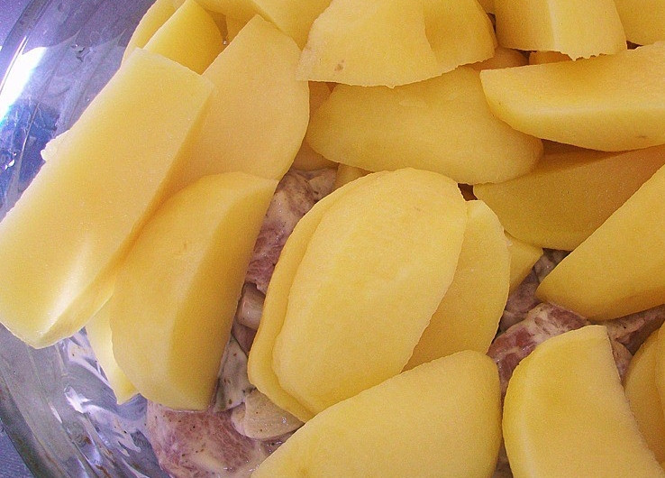 1. Этап. Картофель со свининой в сметане: Картофель очищаем и режем дольками. Перемешиваем мясо с картофелем и выкладываем ы форму для запекания, смазанную растительным маслом.