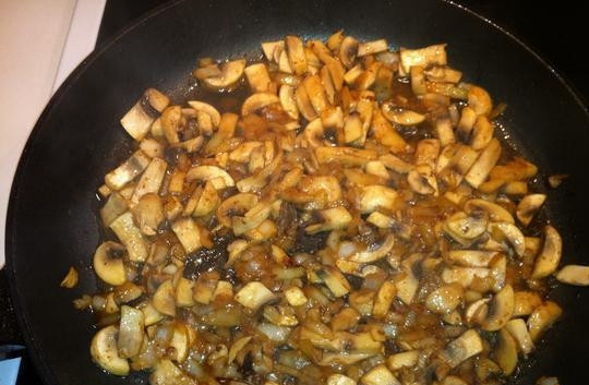 1. Этап. Говядина в сливочно-грибном соусе: Обжарьте лук на сковороде в масле около двух минут. Далее добавьте грибы. Жарьте 5 минут, а потом влейте вино.