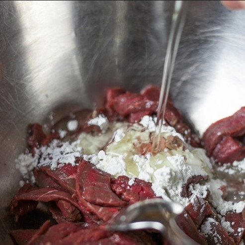 1. Этап. Говядина с брокколи: В миске смешиваем нарезанную говядину, кукурузный крахмал и половину растительного масла. Хорошенько перемешиваем.