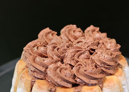 1. Этап. Шоколадный торт Шарлотта: Украсьте торт оставшимся муссом и стружкой из белого шоколада.