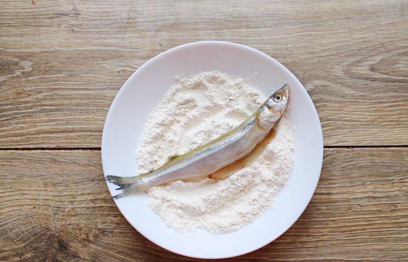 1. Этап. Корюшка жареная: Смешайте муку с солью и полностью запанируйте в ней рыбу.