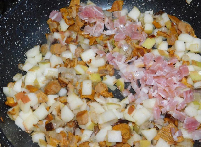 1. Этап. Фаршированные свиные отбивные: Первым делом необходимо приготовить начинку для фарширования. Обжарьте грибы с луком. Добавьте мелко нарезанные яблоки и бекон. Прожарьте все вместе, чтобы яблоки стали мягкими, немного посолите.