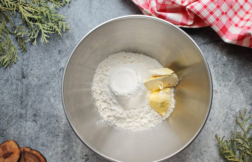 1. Этап. Крекеры с бананом: Соедините пшеничную муку, соду, просейте в миску. Добавьте соль, перемешайте, выложите сливочное масло и быстро перетрите все в мучную крошку.