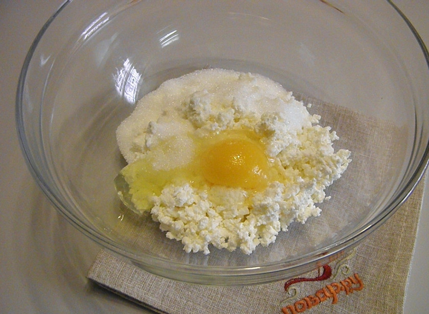 1. Этап. Вергуны на творожном тесте: Возьмите глубокую удобную тару для смешивания продуктов. Поместите в нее творог, сахар и яйцо. Вилочкой тщательно перемешайте, тем самым убирая комочки и как бы растирая творог.