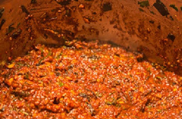 1. Этап. Аджика Кавказская на зиму: 10. Добавьте зелень, все перемешайте и снимите с огня.