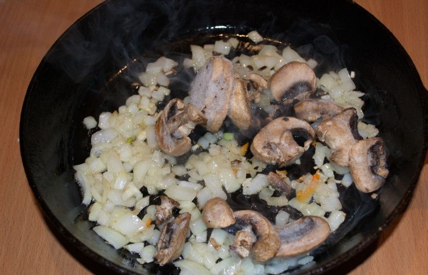 1. Этап. Мясо по-староуральски: На растительном масле обжарьте лук. Добавьте нарезанные грибы, тушите все вместе. Теперь добавьте морковь. Тушите до мягкости.