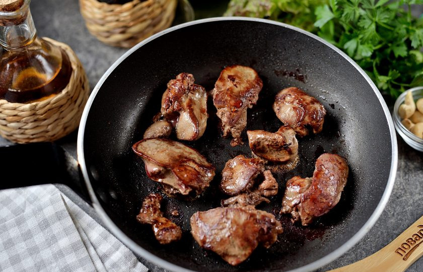 1. Этап. Салат с печенью, сладким перцем, помидорами и орехами: Печень помойте, обсушите насухо бумажными полотенцами, разрежьте пополам. Разогрейте в сковороде растительное масло, обжарьте печень с обеих сторон по 3-4 минуты на умеренном огне.