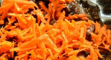 1. Этап. Морковь с грибами тушеная: Добавьте к грибам тертую морковь, все перемешайте.