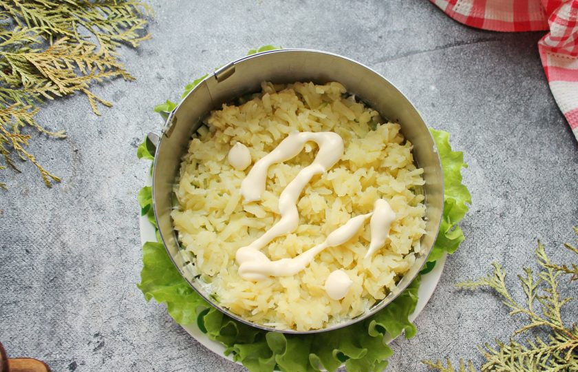 1. Этап. Салат с красной рыбой и креветками слоями: Сверху выложите слой из оставшегося картофеля и смажьте майонезом.