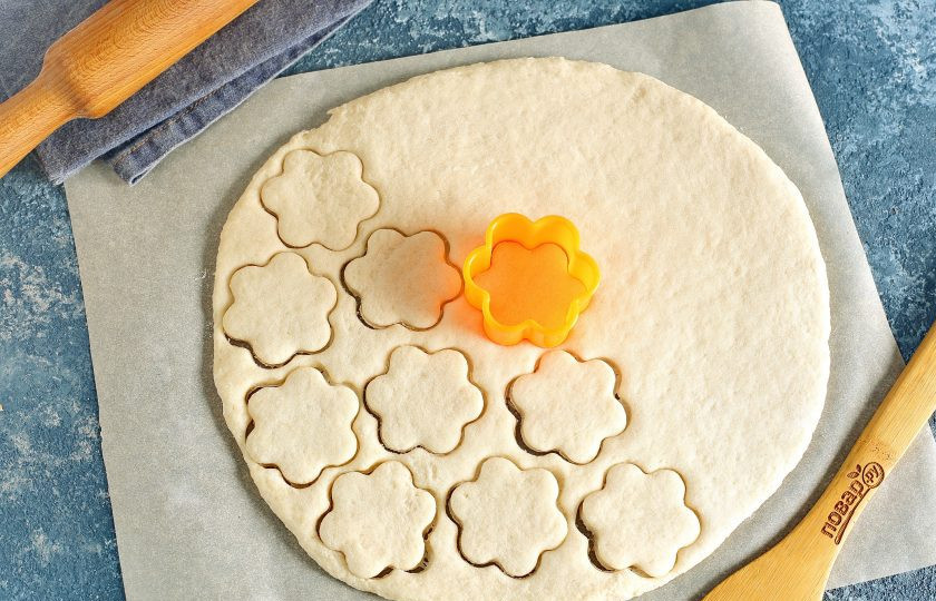 1. Этап. Сладкое на сковороде: Рабочую поверхность посыпьте мукой и раскатайте тесто в пласт, толщиной не менее 5 мм. При помощи формочек или обычного стакана вырежьте фигурки.