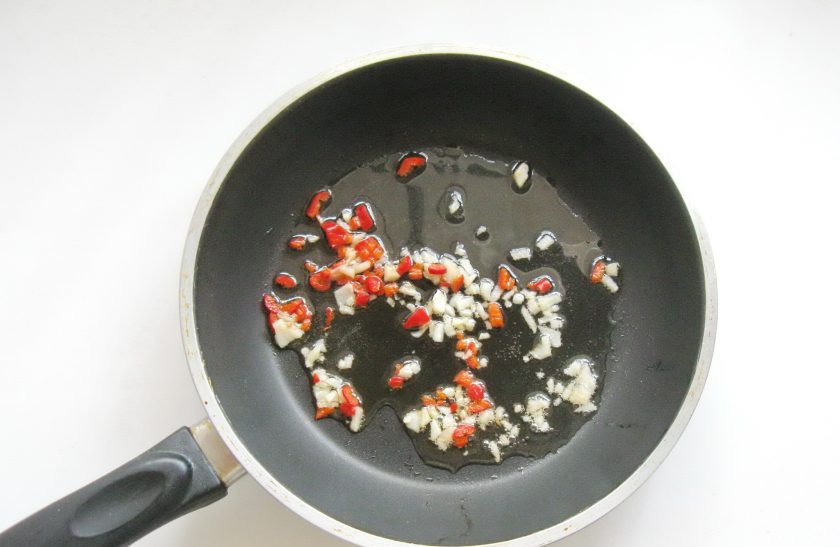 1. Этап. Острая закуска из баклажанов: Обжарьте перец с чесноком в масле в течение 6-7 секунд и выключайте.