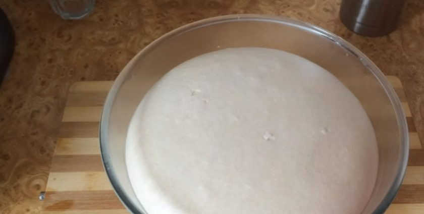 1. Этап. Сдобные рогалики с кунжутом: 3. Готовое тесто округлите, выложите в смазанную растительным маслом миску и накройте пленкой. Оставьте при комнатной температуре на 3 часа. Выложите тесто на рабочую поверхность, присыпанную мукой.