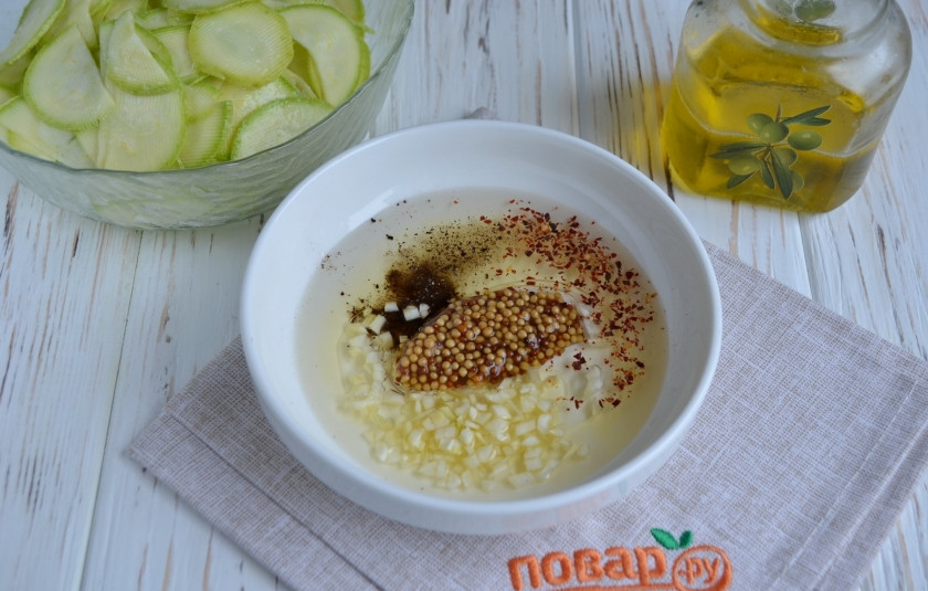 1. Этап. Острая закуска из кабачков: Приготовьте маринад из растительного масла, уксуса, горчицы, чеснока, двух видов перца и меда. Перемешайте хорошо.