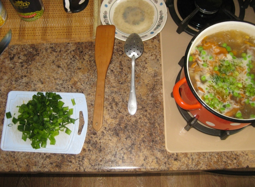 1. Этап. Суп грибной с лисичками: Нарезанный зеленый лук отправляем в кастрюлю после того, который жарился на сковородке.