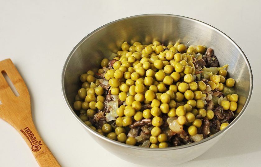 1. Этап. Постный Оливье с грибами: Добавьте зеленый горошек, предварительно слив с него всю жидкость.