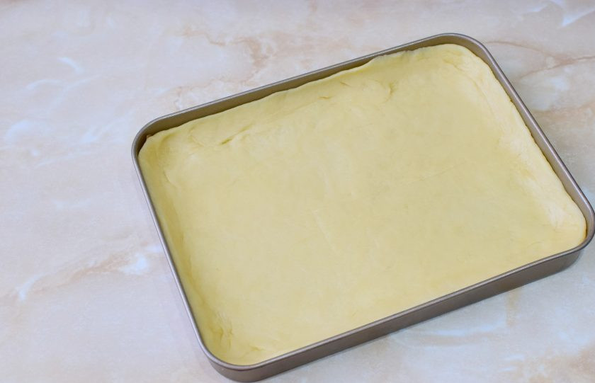 1. Этап. Венский пирог с вареньем: Тесто разделите на две неравные части. Меньшую часть уберите в морозилку, чтобы оно застыло. Большую часть выложите в форму для выпечки и распределите по всему дну, формируя небольшие бортики.
