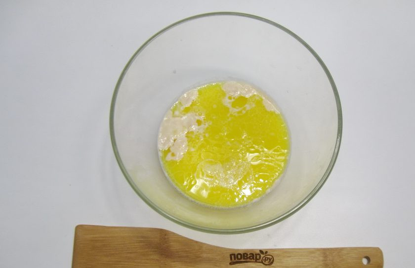 1. Этап. Пирожки с конфетами: Сливочное масло растопите, немного охладите и добавьте в миску с молоком и дрожжами.