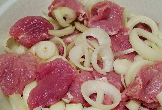 1. Этап. Шашлык из свинины с луком: Для начала мы тщательно промываем свинину и вытираем ее бумажными салфетками, затем нарезаем мясо на небольшие кусочки (4 см шириной) и выкладываем их в глубокую посуду. Репчатый лук чистим и 1-2 луковицы перекручиваем через мясорубку или измельчаем в блендере, остальной лук нарезаем крупными кольцами, выкладываем тертый и нарезанный лук в миску с мясом, аккуратно все перемешиваем.