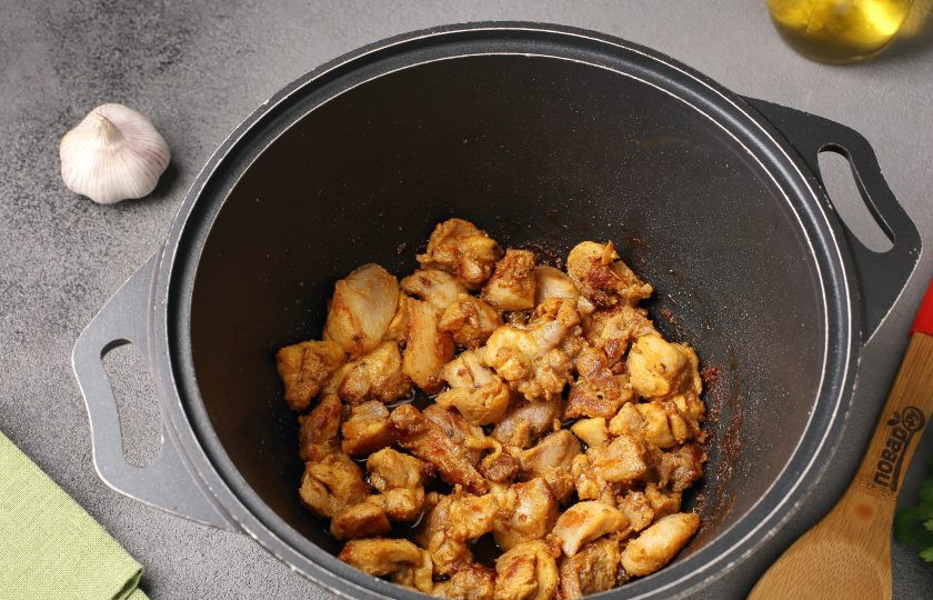 1. Этап. Ближневосточный плов с курицей и помидорами: В казане разогрейте масло, выложите кусочки мяса и обжарьте периодически помешивая на максимальном огне до полуготовности. Затем выложите пока на отдельную тарелку.