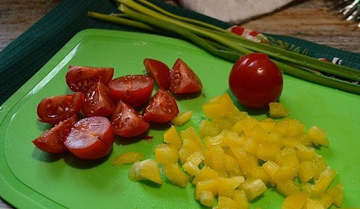 1. Этап. Салат Новогодняя ярмарка: Овощи вымыть, обсушить, нарезать перец - кубиком, помидоры - четвертинками. Слегка посолить.