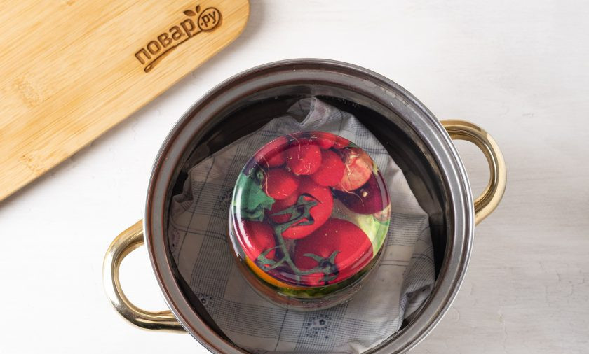 1. Этап. Салат на зиму с огурцами и помидорами: Постелите на дно кастрюли тряпочку, поставьте банку и влейте воду по плечики. Доведите до кипения и стерилизуйте 10 минут.