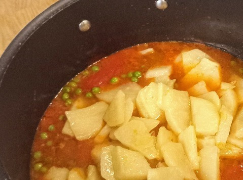 1. Этап. Карри из картофеля и зелёного горошка: Наконец, добавить зелёный горошек, вернуть в казан отложенный картофель и 200 мл воды. Довести до кипения, уменьшить огонь и тушить 7 минут. Посолить по вкусу