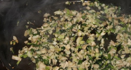 1. Этап. Шампиньоны, запеченные с сыром: В сковороду с зеленью добавить нарезанные ножки грибов и помешивая тушить 15 минут. Добавить соли по вкусу. Выложить в чашку.